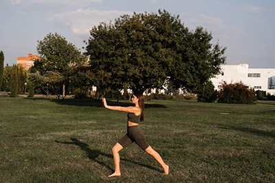 Ragazza asiatica fa tai chi sull'erba verde